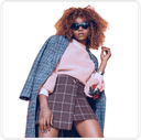 A woman with curly hair wearing stylish glasses and a chic jacket stands against a white background. This image represents a version producwithout AI touch. Highlight how using AI Ads and AI creatives for Black Friday sales can boost sales. Suitable product catalogs can be created for e-commerce platforms, including Shopify.