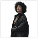 A sweet woman with curly hair wearing a black oversized jacket against a white background.   This image represents a version without AI touch. Highlight how using AI Ads and AI creatives for Black Friday sales can boost sales. Suitable product catalogs can be created for e-commerce platforms, including Shopify.